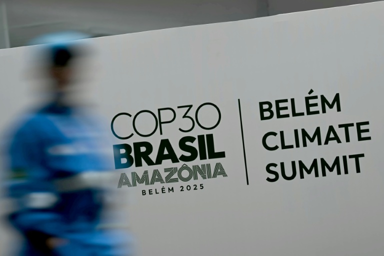 Une personne passe devant le logo de la COP30 à Belem, Brésil, le 5 novembre 2025