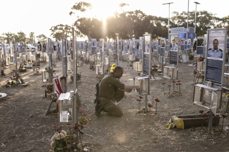 Un soldat israélien allume une bougie au mémorial dédié aux victimes des attaques du Hamas de 2023, sur le site du festival Nova à Reim, dans le sud d'Israël, le 7 octobre 2026