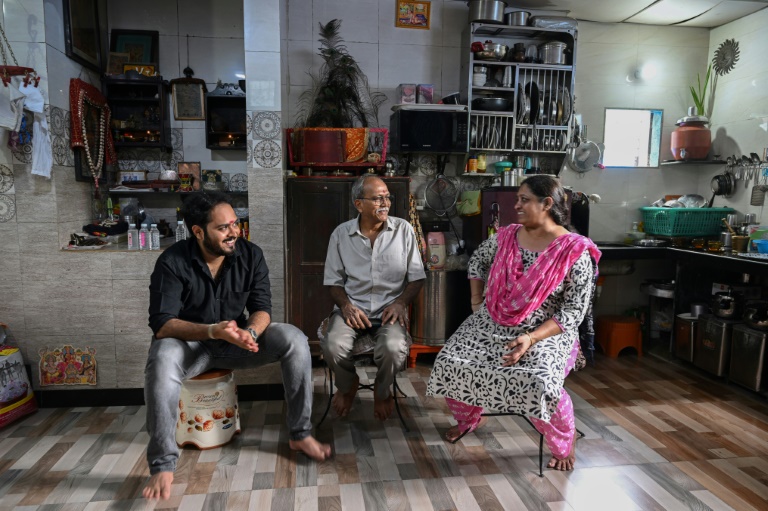 Bipinkumar Padaya (c), son épouse Jaya Padaya (d) et leur fils Darshan Padaya, éligibles à une relocalisation dans le cadre d'un projet de rénovation urbaine, lors d'un entretien avec l'AFP dans leur maison de Dharavi, un bidonville de Bombay, le 8 juillet 2025 en Inde