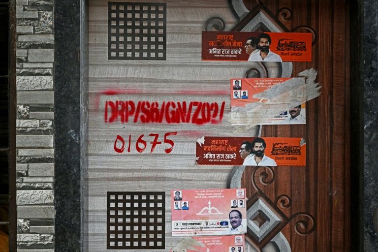 Une marque rouge sur la porte d'une maison dans le cadre d'un projet de rénovation urbaine du bidonville de Dharavi, le 8 juillet 2025 à Bombay, en Inde