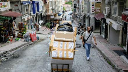 Un porteur pousse un chariot chargé de cartons dans le quartier de Laleli, à Istanbul, le 27 mai 2025 en Turquie