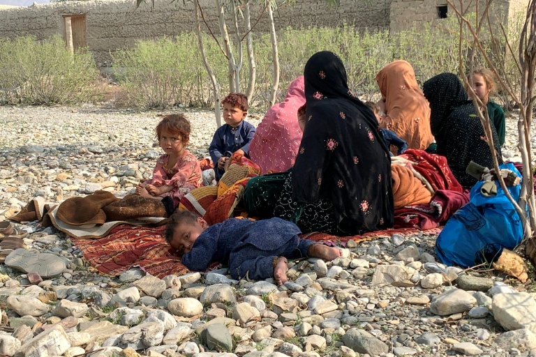 Des rapatriés afghans sont assis dans un champ après avoir échappé à un bombardement nocturne pakistanais près du poste-frontière de Torkham, dans la province de Nangarhar, Afghanistan,le 27 février 2026