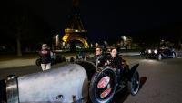 Une voiture de collection Bugatti sur le champ de Mars, devant la tour Eiffel, durant la parade nocturne pour les 50 ans de Rétromobile, le 26 janvier 2026, à Paris