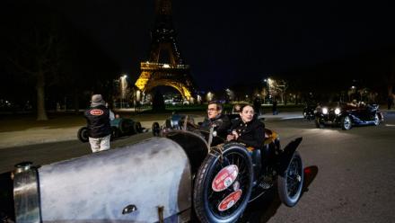 Une voiture de collection Bugatti sur le champ de Mars, devant la tour Eiffel, durant la parade nocturne pour les 50 ans de Rétromobile, le 26 janvier 2026, à Paris