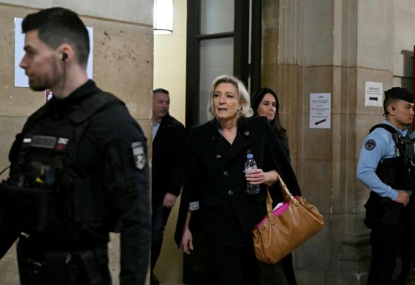 Marine Le Pen (c), présidente du groupe parlementaire du Rassemblement National (RN), accompagnée de Catherine Griset (d), eurodéputée du RN, arrive au tribunal de Paris, le 20 janvier 2026, pour l'audience en appel des assistants parlementaires du Rassemblement National (RN) soupçonnés de détournement de fonds publics européens