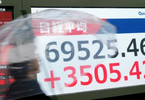 Un écran diffuse les cours des indices boursiers à Tokyo, le 15 juin 2026