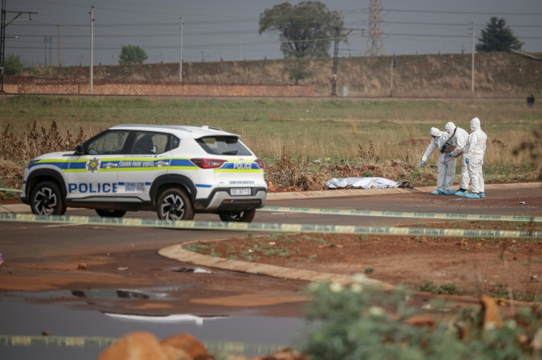Des membres de la police scientifique s'affairent près du corps d'une femme retrouvée morte le 17 septembre 2026 à Boksburg (Afrique du Sud), à l'est de Johannesburg