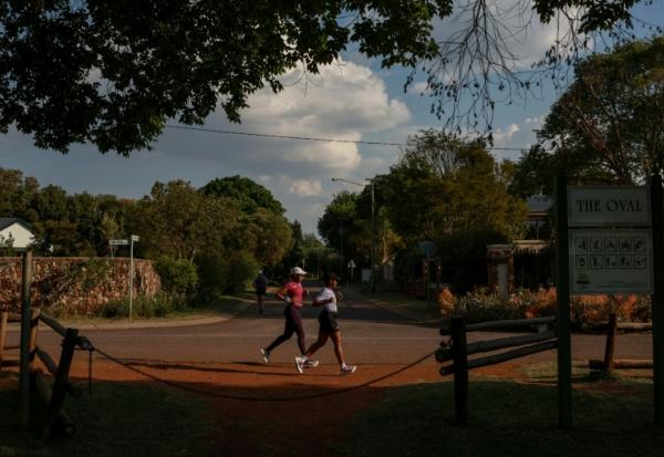 Nancy Masha (D) et Babalwa Melitafa (G) font leur jogging dans un lotissement sécurisé à Irene, près de Pretoria, en Afrique du Sud, le 21 septembre 2026