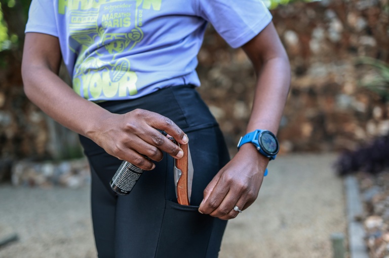 Nancy Masha montre le couteau et la bombe lacrymogène qu'elle emmène avec elle pour courir, à Irene (Afrique du Sud), près de Pretoria, le 21 septembre 2026
