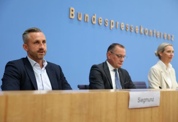 (g-d) Ulrich Siegmund, tête de liste du parti d'extrême droite Alternative pour l'Allemagne (AfD) aux élections régionales de Saxe-Anhalt, les coprésidents de l'AfD Tino Chrupalla et Alice Weidel et d'autres membres du parti chantent l'hymne national lors de la soirée électorale à Magdebourg, le 6 septembre 2026 dans l'est de l'Allemagne