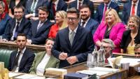 Photo diffusée par le Parlement britannique du nouveau député travailliste de Makerfield, Andy Burnham (c), souriant, après avoir signé le registre à la suite de sa prestation de serment à la Chambre des communes, le 22 mai 2026 à Londres 
