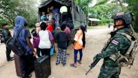 Des personnes de différentes nationalités qui travaillaient dans le complexe KK Park en Birmanie et ont traversé la frontière thaïlandaise par une rivière, montent à bord d'un véhicule sous la surveillance de soldats thaïlandais dans le district de Mae Sot, dans la province thaïlandaise de Tak, le 24 octobre 2025