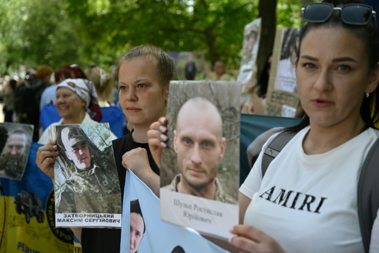 Des Ukrainiens brandissent des portraits de leurs parents captifs ou disparus dans l'espoir qu'ils seront reconnus par l'un ou l'autre des prisonniers de guerre libérés dans le cadre d'un échange avec la Russie, le 23 mai 2025