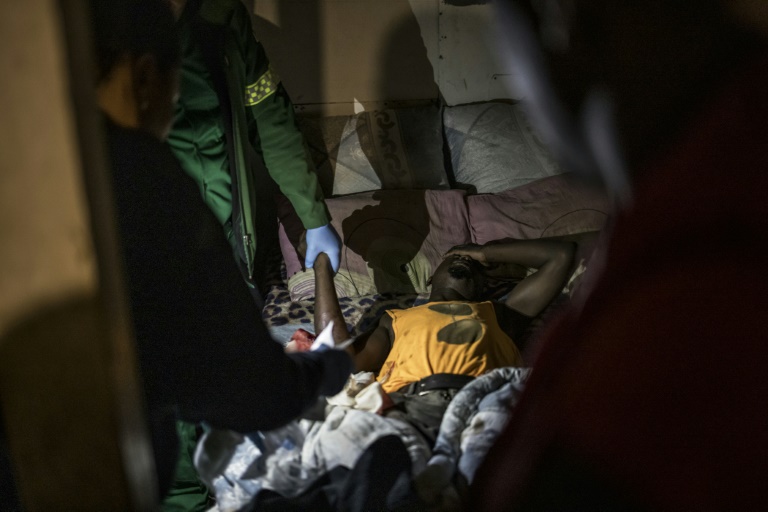 Un blessé est pris en charge par des ambulanciers lors d'une intervention au township Philippi, près du Cap, le 15 avril 2025 en Afrique du Sud