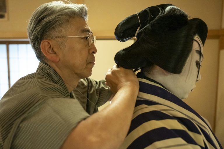 Le maître perruquier Tadashi Kamoji (g) aide l'acteur Tanenosuke Nakamura à mettre sa perruque avant une représentation au théâtre Kabuki-za à Tokyo, le 13 avril 2026