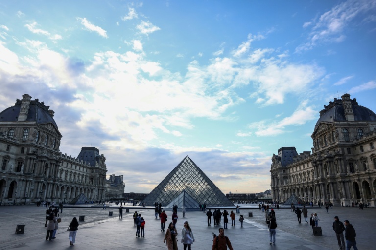 Des touristes près de la pyramide du Louvre, conçue par l'architecte sino-américain Ieoh Ming Pei, le 28 février 2025