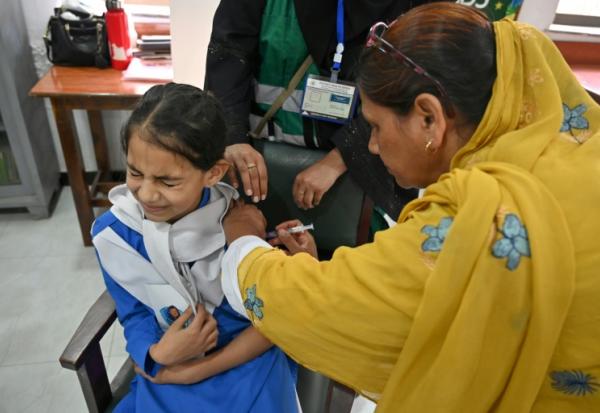 Une soignante (g) administre le vaccin contre le virus du papillome humain (VPH) à une adolescente, lors d'une campagne de vaccination contre le cancer du col de l'utérus, le 24 septembre 2025 à Karachi, au Pakistan
