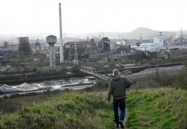 Un visiteur descend un terril près d'aciéries abandonnées à Charleroi, dans le sud de la Belgique, le 11 mars 2026