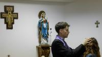 Le prêtre Francisco Marques appose ses mains sur la tête d'une femme lors d'une séance d'exorcisme, le 30 mai 2026 à Fatima, au Portugal