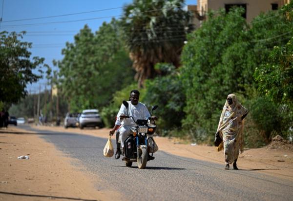 Un bénévole soudanais chargé de livrer des médicaments à domicile roule en moto à Khartoum, le 18 avril 2026