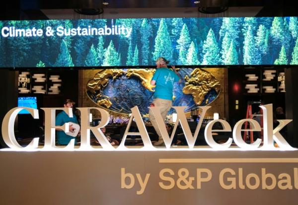 Deux hommes travaillent pour préparer le plus grand rendez-vous mondial des acteurs du pétrole, le 22 mars 2026 à Houston, au Texas