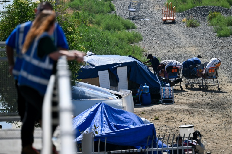 Des employés d'une association d'aide aux sans-abris veillent sur un campement de SDF, à Los Angeles, le 1er juin 2026