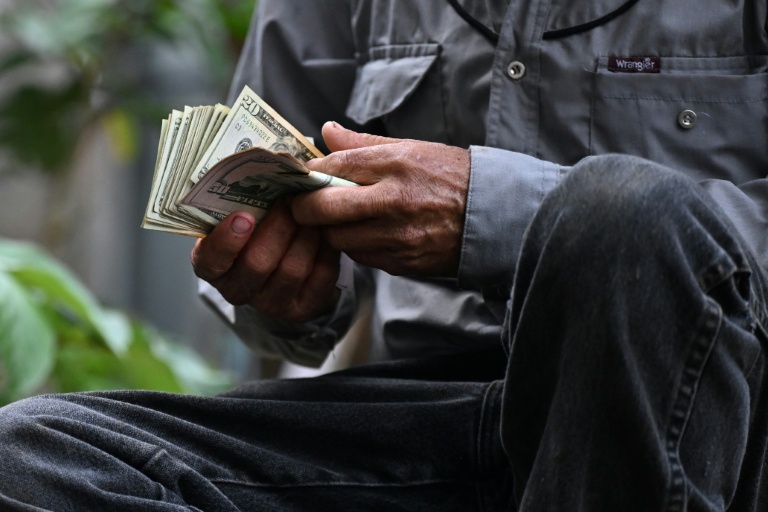 Un vendeur de bétail compte son argent après avoir conclu une vente au Marché municipal du bétail de Sensuntepeque, dans le département de Cabañas, au Salvador, le 1er octobre 2026