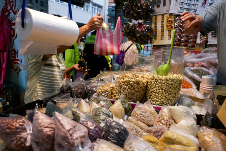 Un commerçant met des produits dans un sac en plastique sur un marché de Keelung, à Taïwan, le 9 juin 2026
