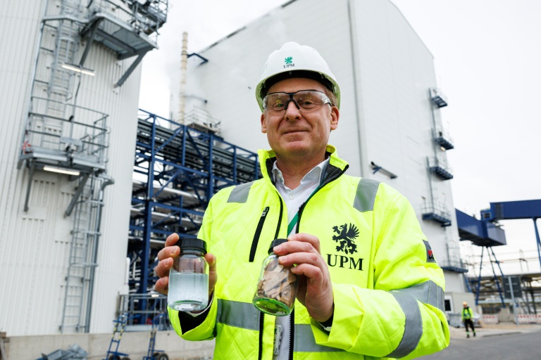 Harald Dialer, vice-président exécutif Technologie d'UPM Biorefining & Technology, présente un bocal contenant des copeaux de bois de hêtre et un autre contenant le produit final, la monoéthylène glycoline, devant les installations chimiques d'UPM Biorefining & Technology dans le parc chimique de Leuna, le 14 novembre 2024