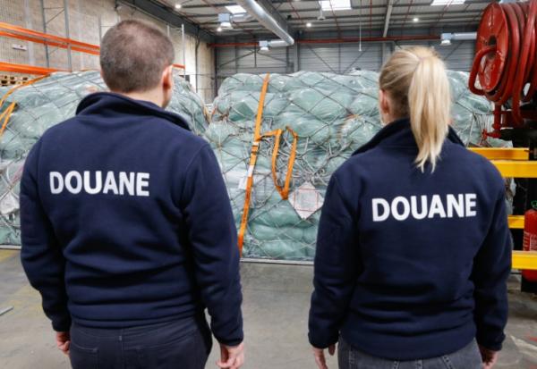 Des douaniers devant des colis de fret aérien dans un entrepôt de l'aéroport Roissy-Charles-de-Gaulle, au nord de Paris, le 29 avril 2025