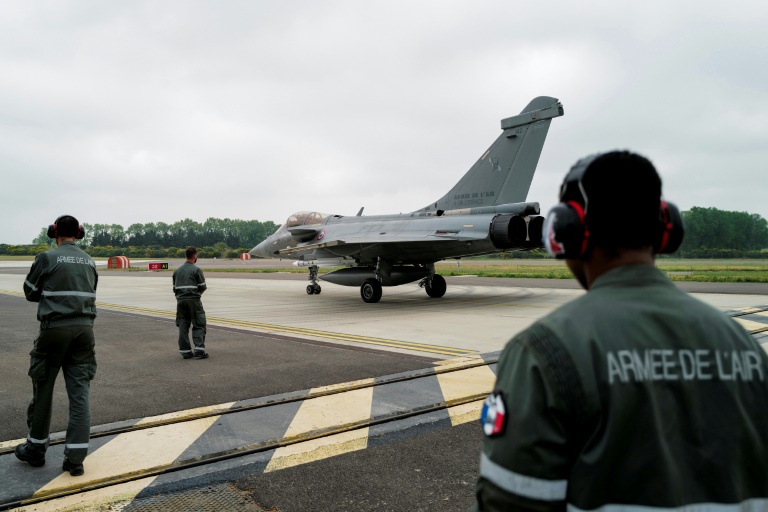 Des membres de la Force aérienne et spatiale française observent un avion de chasse Rafale roulant sur le tarmac de la base aérienne 115 à Orange, dans le Vaucluse, le 28 avril 2026