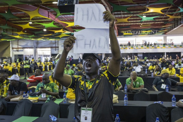 Lors d'une réunion du Congrès national africain (ANC) à Johannesburg, le 16 décembre 2022, un délégué brandit une pancarte où l'on peut lire 