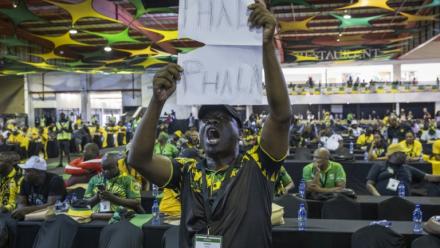 Lors d'une réunion du Congrès national africain (ANC) à Johannesburg, le 16 décembre 2022, un délégué brandit une pancarte où l'on peut lire "Phala Phala", en référence à un vol survenu dans la ferme du même nom appartenant au président sud-africain Cyril Ramaphosa
