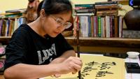 Hoang Thi Thanh Huyen apprend la calligraphie chez le calligraphe Nguyen Thanh Tung, le 15 mai 2025 à Hanoï, au Vietnam