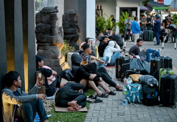 Des personnes qui ont quitté les centres d'escroquerie en ligne attendent devant l'ambassade indonésienne à Phnom Penh au Cambodge le 21 janvier 2026