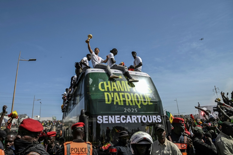Les Sénagalais champions d'Afrique présentent leur trophée à la foule de Dakar, mardi 20 janvier 2026.