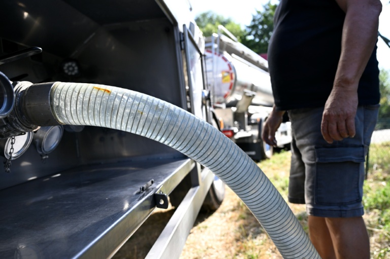 Un employé raccorde un tuyau à un camion-citerne transportant de l'eau potable pour approvisionner la commune de Sainte-Marie-aux-Mines, le 11 août 2026 dans le Haut-Rhin