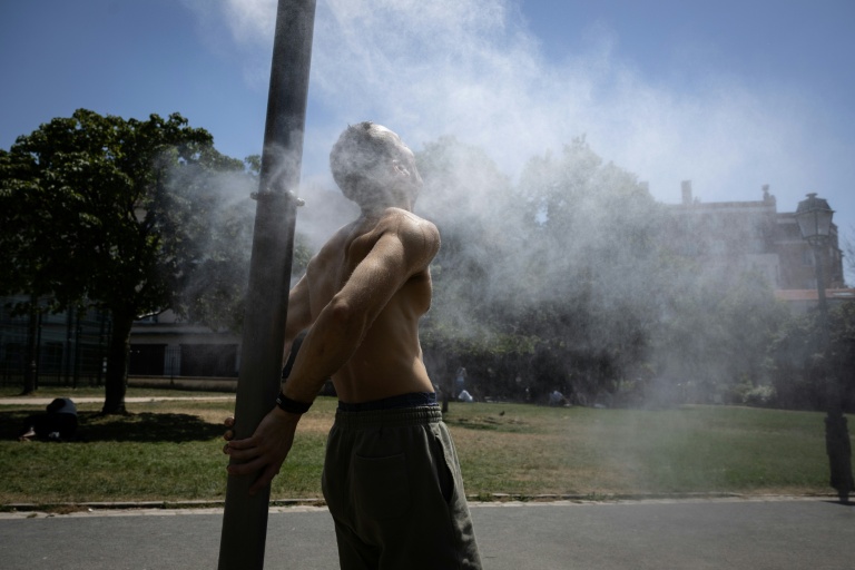 Un homme se rafraîchit sous une fontaine à Paris le 24 juin 2026 