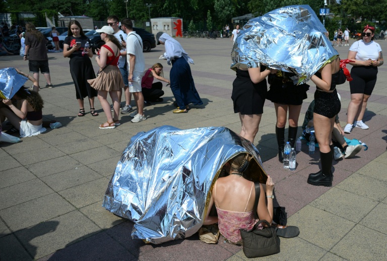 Des spectateurs se protègent de la chaleur avant un concert de Bruo Mars à l'Olympic stadium  de Berlin, le 28 juin 2026