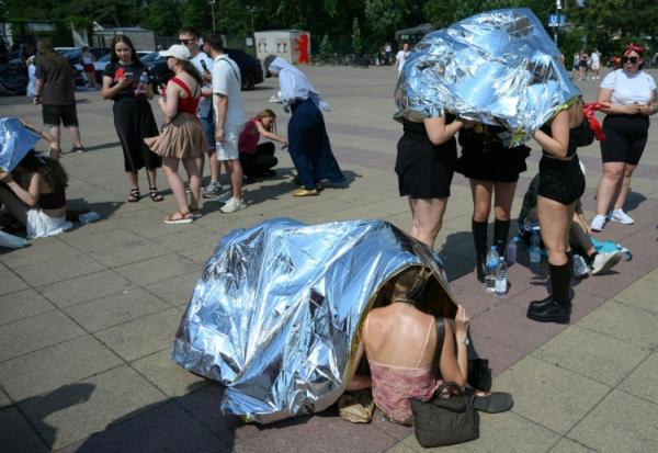 Des spectateurs se protègent de la chaleur avant un concert de Bruo Mars à l'Olympic stadium  de Berlin, le 28 juin 2026