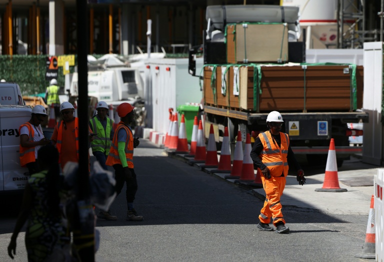 Des ouvriers du bâtiment se regroupent à l'ombre sur un chantier du centre de Londres, le 24 juin 2026