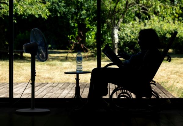 Une personne âgée assise face à un ventilateur à Pont-Audemer, dans l'Euroe, le 12 juillet 2026 lors d'une vague de chaleur en France