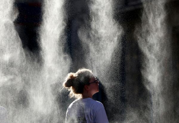 Une personne se rafraîchit avec des brumisateurs, le 21 juin 2026 à Bordeaux