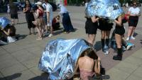 Des spectateurs se protègent de la chaleur  avec des couvertures de survie avant un concert de Bruo Mars à l'Olympic stadium de Berlin, le 28 juin 2026 en Allemagne