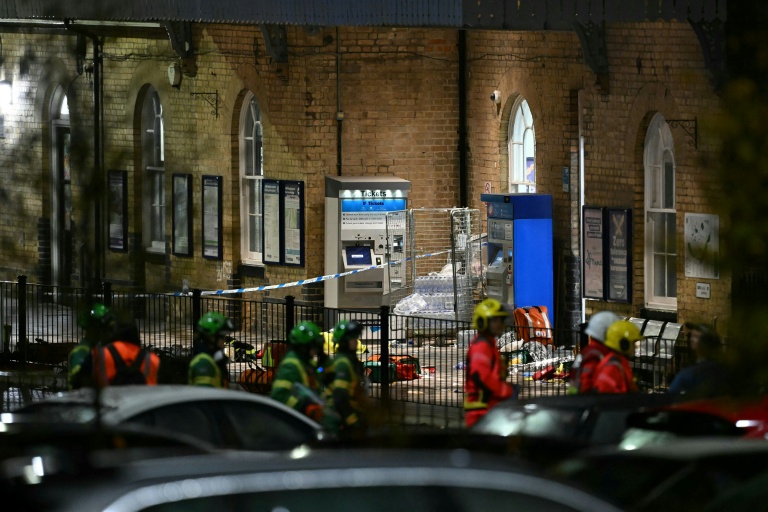 Policiers et secouristes devant la gare de Huntingdon sur les lieux d'une attaque à l'arme blanche qui a fait au moins 10 blessés dont neuf graves dans un train en direction de Londres, dans l'est de l'Angleterre, le 1er novembre 2025