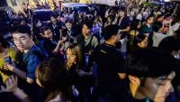 Les employés du centre d'appels surfent sur leurs téléphones portables alors qu'ils se rassemblent devant leur immeuble de bureaux après les secousses du tremblement de terre à Cebu, dans le centre des Philippines, le 30 septembre 2025