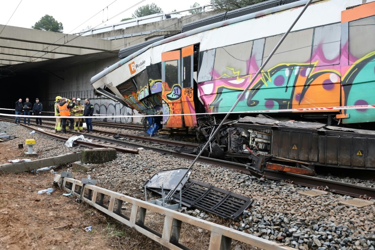 Des enquêteurs et des pompiers sur le site où un train de banlieue a percuté un mur de soutènement tombé sur les voies, le 21 janvier 2026 entre Sant Sadurni d'Anoia et Gelida, près de Barcelone, en Catalogne