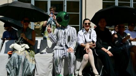 Un invité portant un masque d'extraterrestre assiste au défilé de la collection Thom Browne lors de la Fashion Week Homme Printemps/Été 2027 de Milan, à Milan, le 22 juin 2026