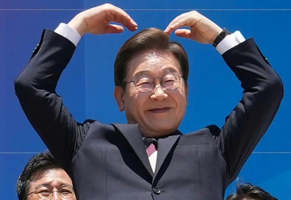 Le président sud-coréen Lee Jae-myung fait fait un cœur avec les bras à l'intention de ses partisans réunis devant l'Assemblée nationale, à Séoul, le 4 juin 2025