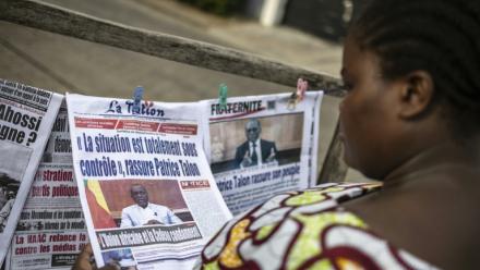 Une habitante regarde les journaux sur un étal dans une rue de Cotonou après une tentative déjouée de coup d'Etat au Bénin, le 8 décembre 2025